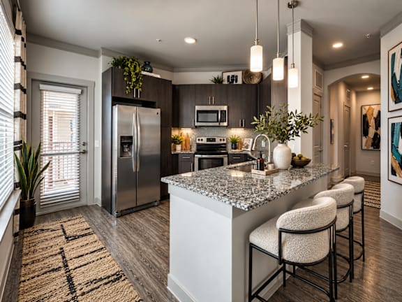 A modern kitchen with a large island and bar stools.