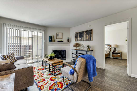 A living room with a fireplace, a chair, and a rug.