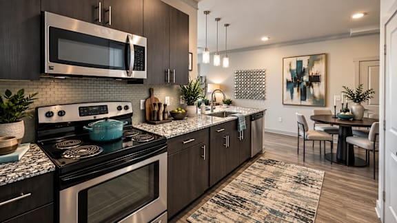 A modern kitchen with dark wood cabinets and a black stove top.
