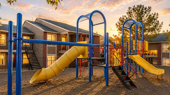 Playground area with slides and climbing equipment at Las Lomas Apartments, El Paso