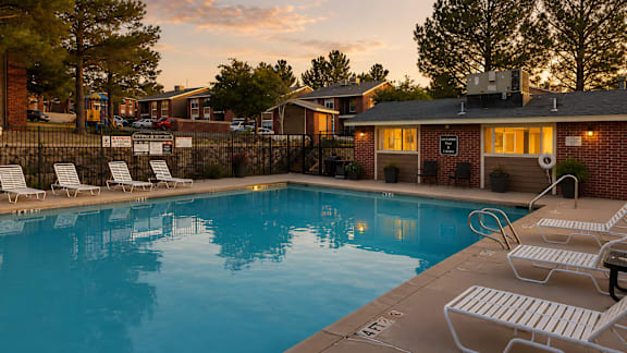 Pool deck with lounge chairs and brick clubhouse at Las Lomas Apartments, Texas, 79912