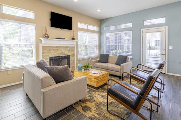 A living room with a fireplace and a flat screen TV mounted above it.
