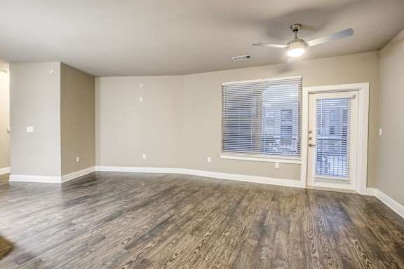 A room with a ceiling fan and a window with blinds.