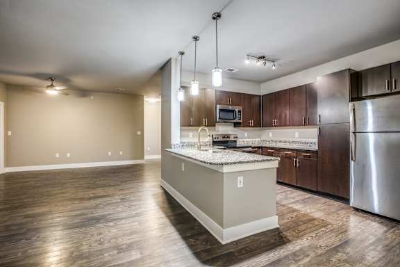 A modern kitchen with a center island and stainless steel appliances.