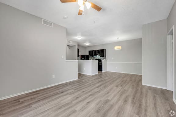 A spacious room with a ceiling fan and lighting fixtures.