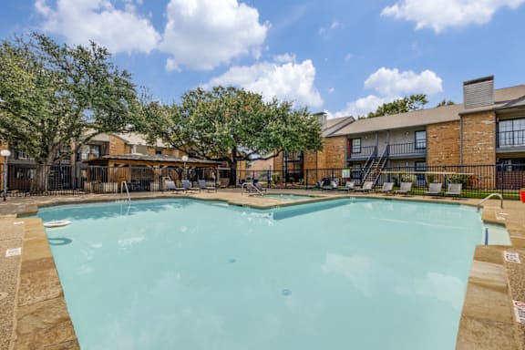 A large swimming pool in front of a brick building.