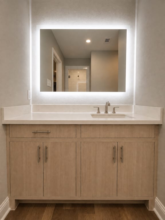 A bathroom with a sink and a mirror above it.