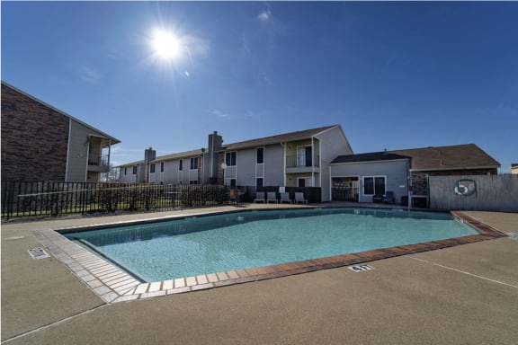 our apartments offer a swimming pool with a blue sky background and our buildings are grey