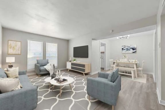 A living room with a grey couch, a white coffee table, and a television.