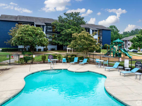 our apartments have a swimming pool with chairs and a playground