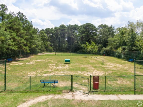 a park with a fenced in field and a park bench