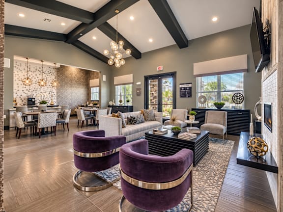 A modern living room with purple chairs and a black and white striped rug.