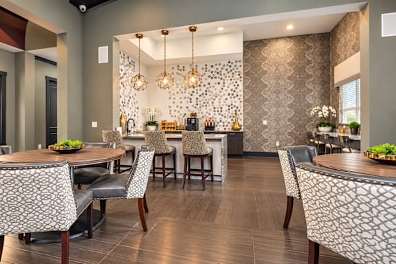 A modern dining room with a patterned wallpaper and a wooden table.