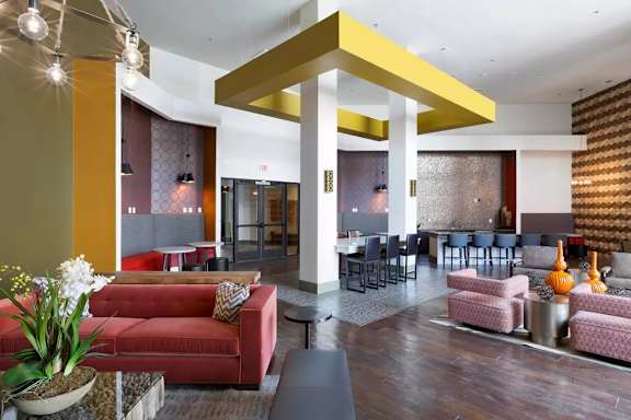 A living room with a red couch and a yellow pillar.