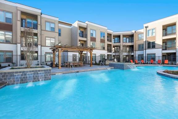 A swimming pool in front of apartment buildings.