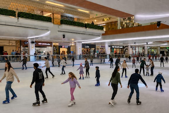 A group of people are skating on an ice rink.