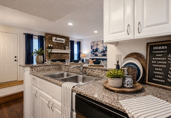 A kitchen with a white theme and a wooden sign that says "Home".