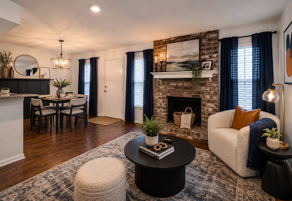 A living room with a fireplace and a dining table.