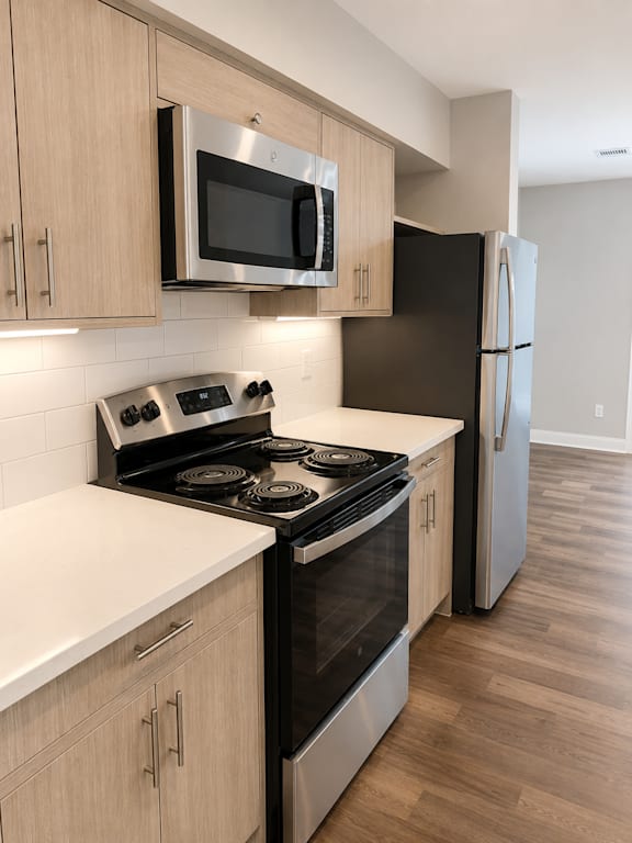 A kitchen with a stove top oven and microwave above it.