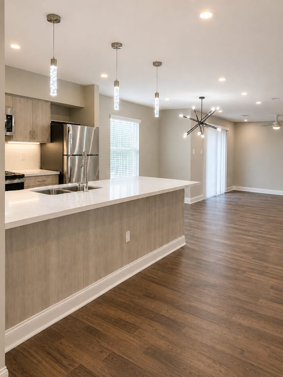 A kitchen with wooden floors and a white counter top.