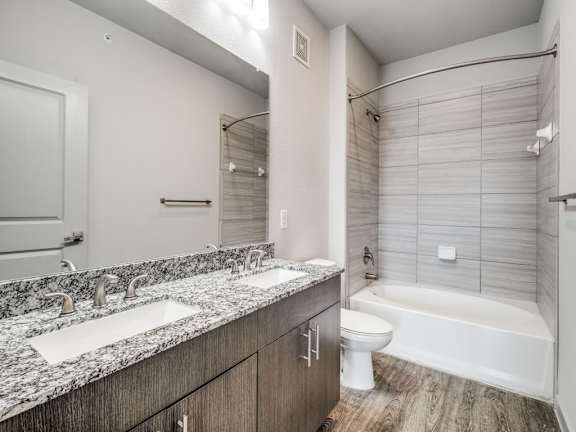 A modern bathroom with a marble countertop and a white toilet.