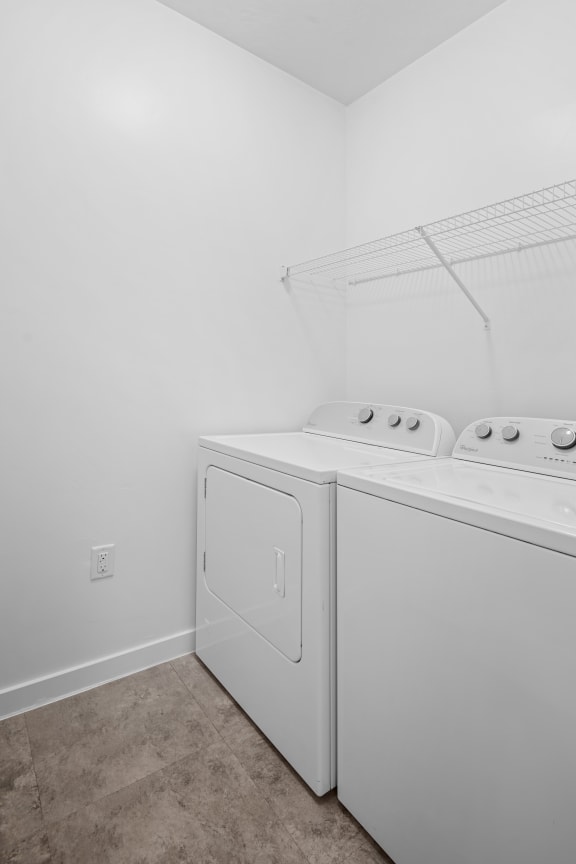 a washer and dryer in a white room with white walls and a ceiling