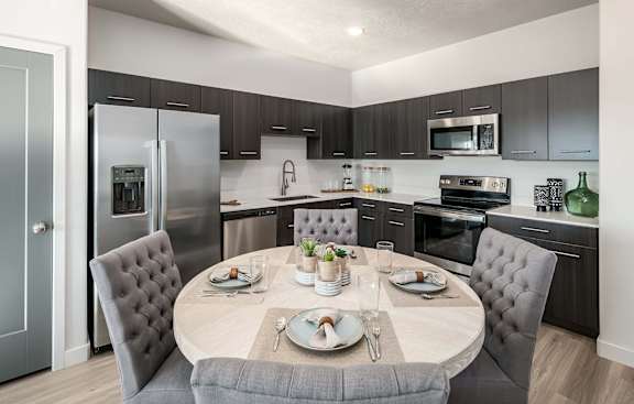 A modern kitchen with a dining table set for two.
