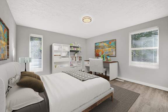 Floor Plan  A bedroom with a bed, desk, and a painting on the wall.