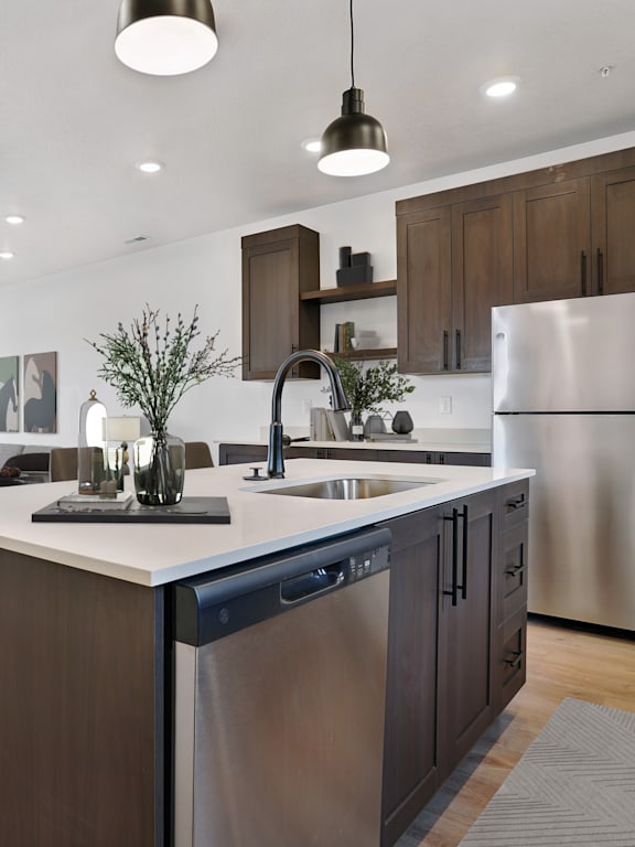 A modern kitchen with a stainless steel refrigerator and dark brown cabinets.
