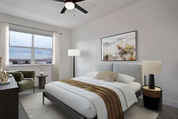 A bedroom with a large bed, a chair, a side table, and a painting on the wall.