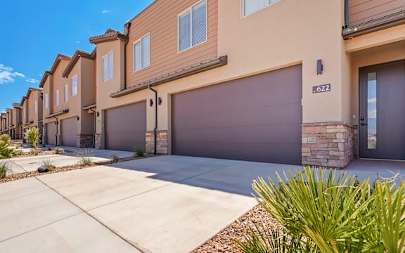 A row of houses with garages and driveways.