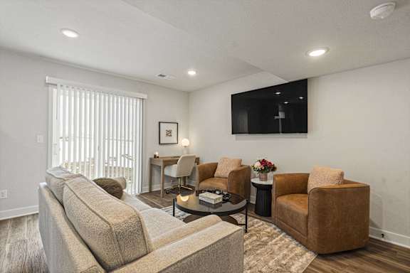 A living room with a couch, chairs, and a coffee table.
