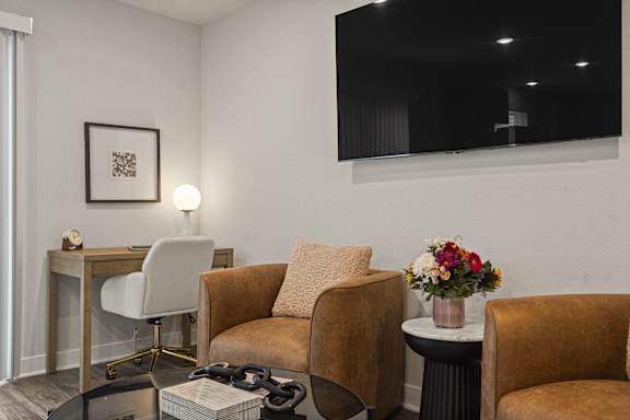 A living room with a brown chair and a white chair.