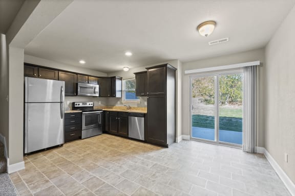 a kitchen with stainless steel appliances and a sliding glass door