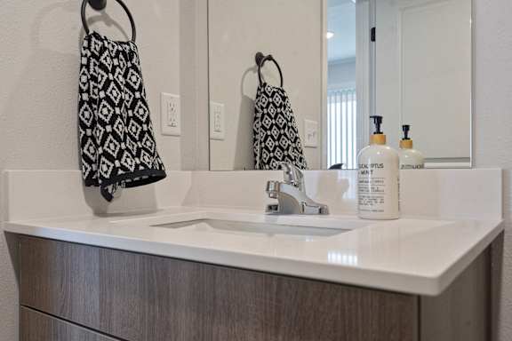 A black and white towel hangs on a towel rack in a bathroom.