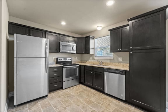 a kitchen with stainless steel appliances and black cabinets