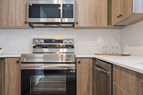 A modern kitchen with a stainless steel oven and microwave above a drawer.