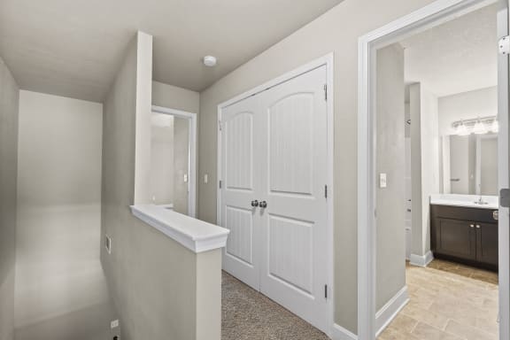 an empty bathroom with white doors and a large white closet