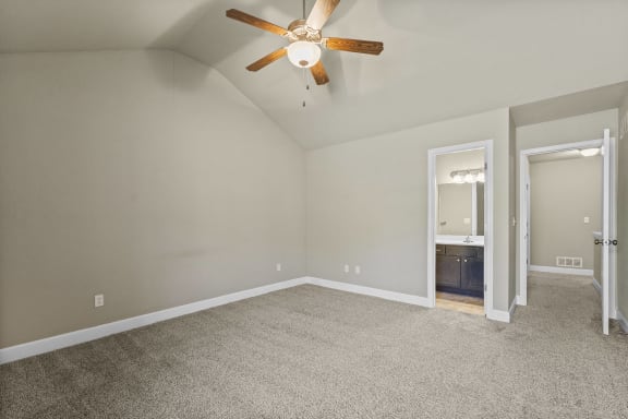 A room with a ceiling fan and carpeted floor.