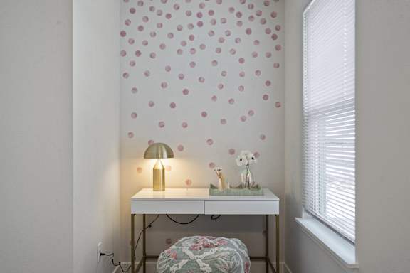 A table with a lamp and some flowers on it.