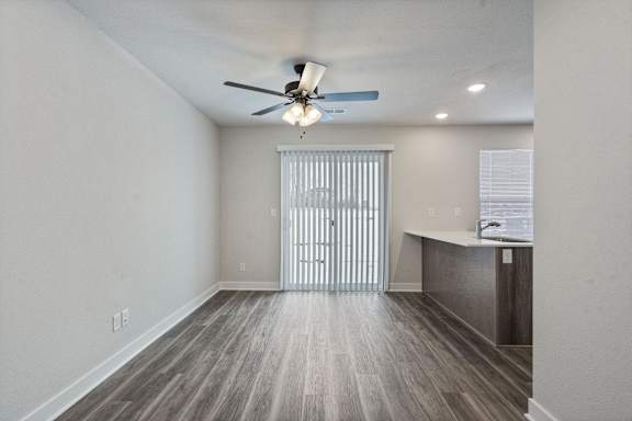 A room with a ceiling fan and a wooden floor.