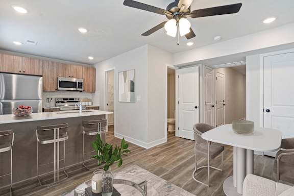 A modern kitchen with a bar area and a dining table.
