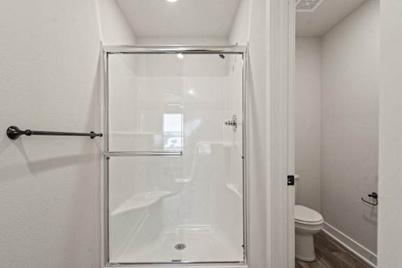 A white bathroom with a walk in shower.