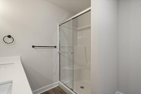 A white bathroom with a glass shower door.