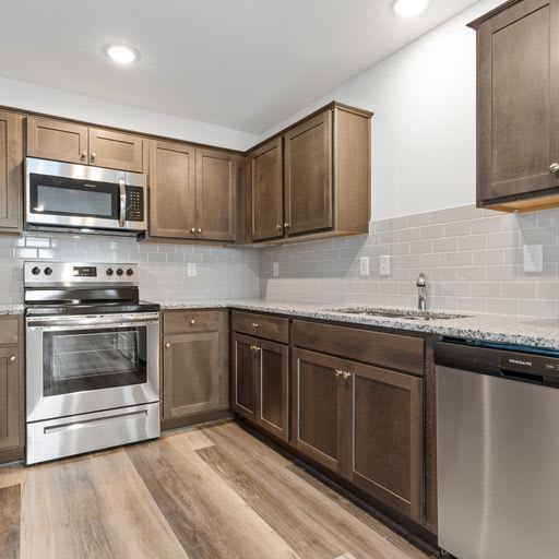 a kitchen with stainless steel appliances and wooden cabinets