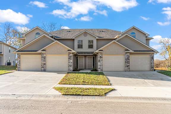 A house with a grey roof and a garage door.