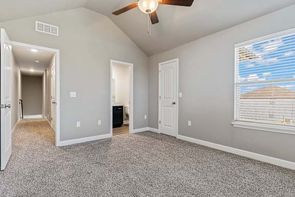 A room with a ceiling fan and a window with blinds.