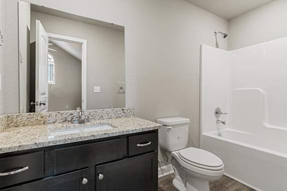 A bathroom with a sink, toilet, and bathtub.