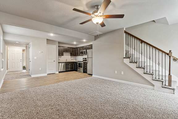 A spacious living room with a staircase leading to the upper floor.