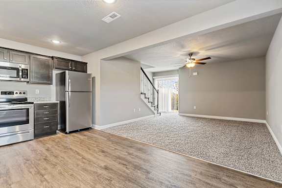 A spacious kitchen with stainless steel appliances and a wood floor.